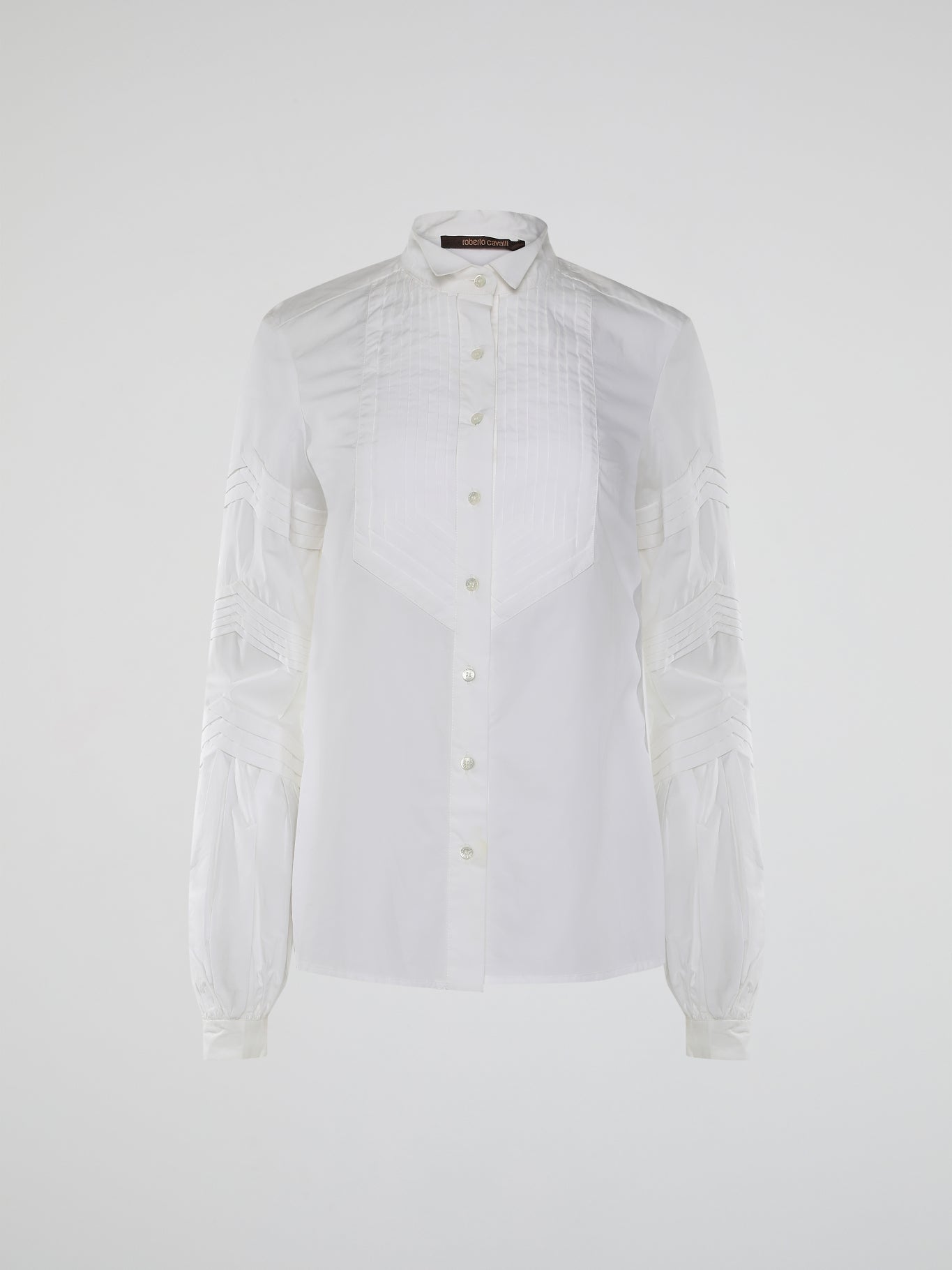 Step into the world of timeless elegance with the White Pleated Bib Shirt from Roberto Cavalli. Crafted with meticulous attention to detail, this masterpiece combines effortless sophistication with a touch of whimsical charm. From its delicate pleated bib to its crisp white fabric, this shirt will make a statement in any setting, exuding refined elegance that is truly captivating.