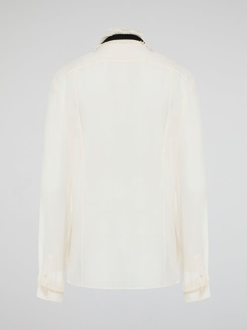 Step into luxury and sophistication with the Roberto Cavalli White Frill Detailed Blouse. The delicate frill detailing adds a touch of elegance to this classic white blouse, making it a perfect choice for any special occasion. Elevate your wardrobe with this timeless piece that exudes high-end fashion and style.